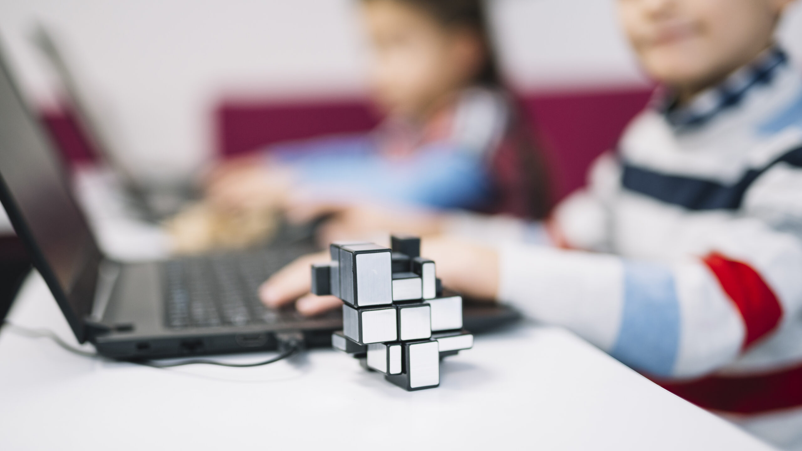 cube-puzzle-front-girl-using-laptop-white-desk